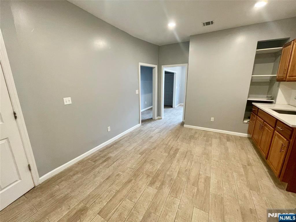 25 Kipp Street Newark, NJ 07108 - Photo 19 of 19 an empty room with wooden floor and cabinet