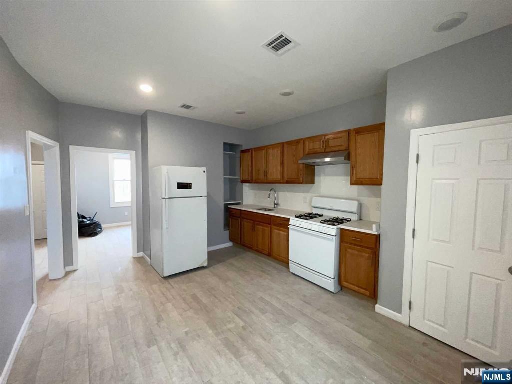 25 Kipp Street Newark, NJ 07108 - Photo 4 of 19 a kitchen with stainless steel appliances granite countertop a refrigerator and a stove top oven