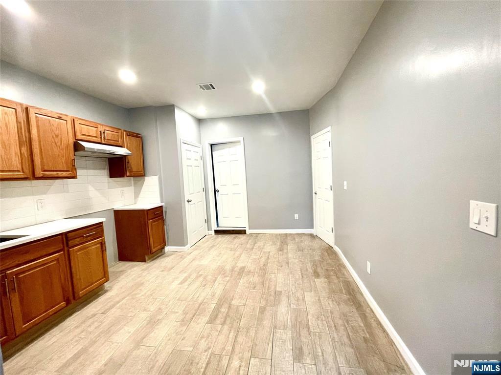 25 Kipp Street Newark, NJ 07108 - Photo 5 of 19 a large kitchen with kitchen island granite countertop a sink and wooden cabinets