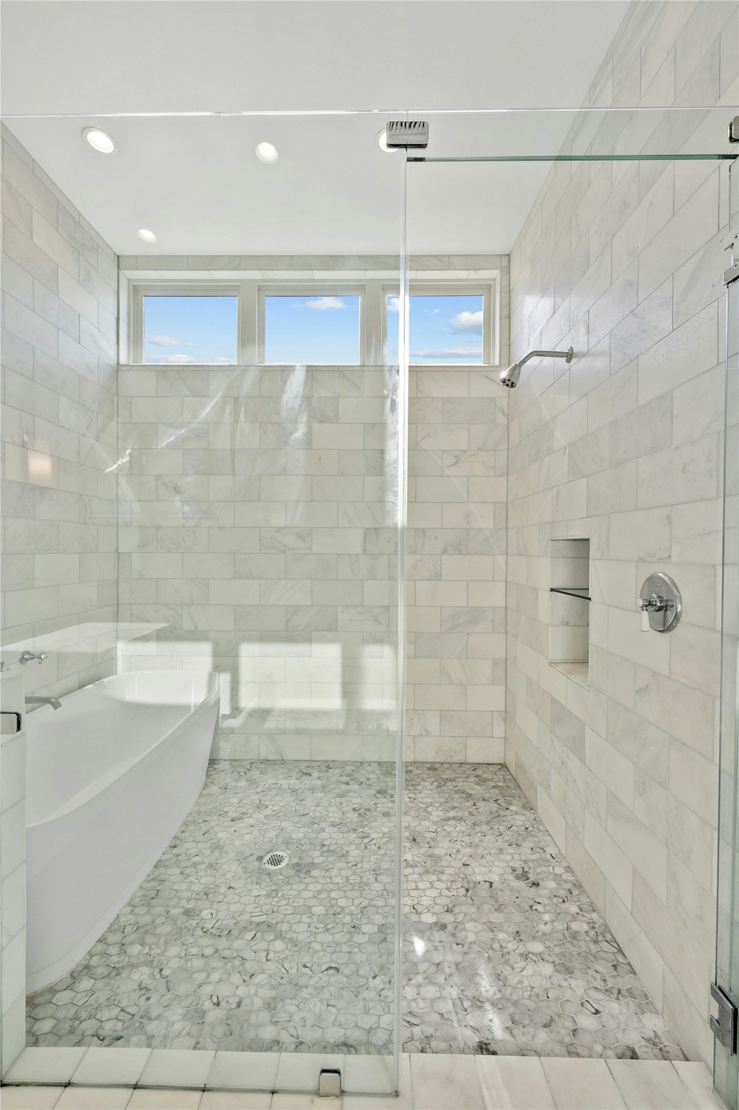 2518 Sutherland Street Austin, TX 78746 - Photo 18 of 30 Luxurious walk-in shower features a standalone soaking tub and natural light from transom windows.