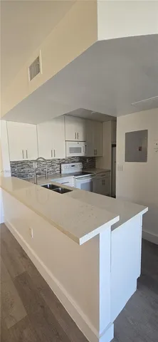 a utility room with granite countertop cabinets washer and dryer