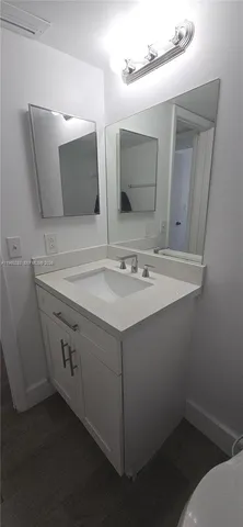 an empty room with wooden floor and entrance