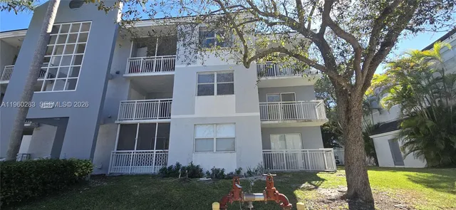 a view of a street with a building and palm trees