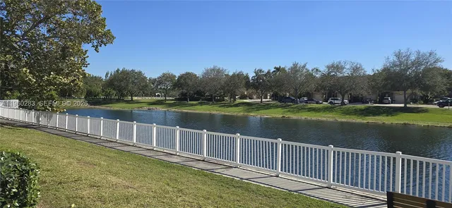 a view of a house with a small yard and large tree