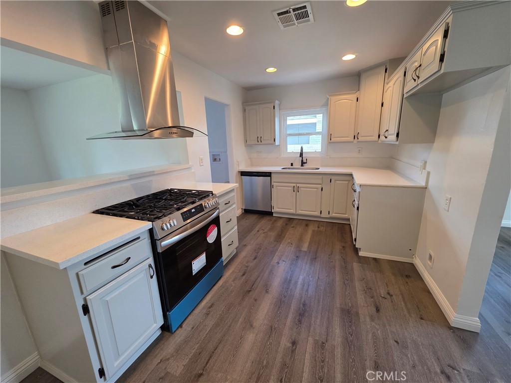 5771 Benecia Drive Riverside, CA 92504 - Photo 1 of 1 a kitchen with a white stove top oven and wooden floor