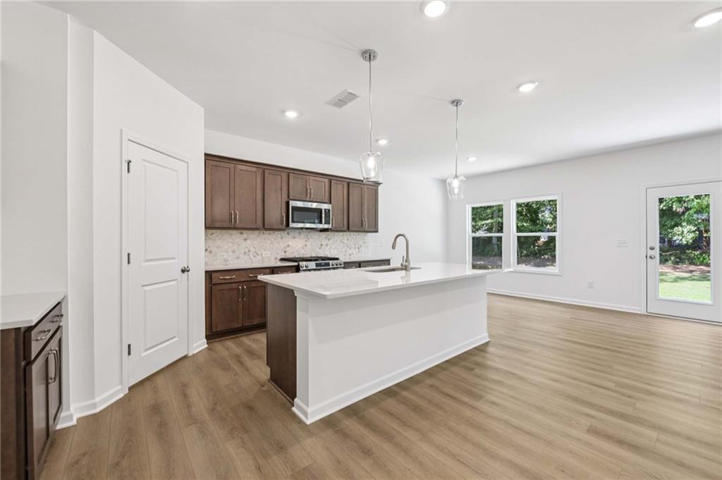 64 Silverleaf Trail Bethlehem, GA 30620 - Photo 11 of 44 a kitchen with stainless steel appliances granite countertop a stove top oven a sink dishwasher a refrigerator and a oven with wooden floors