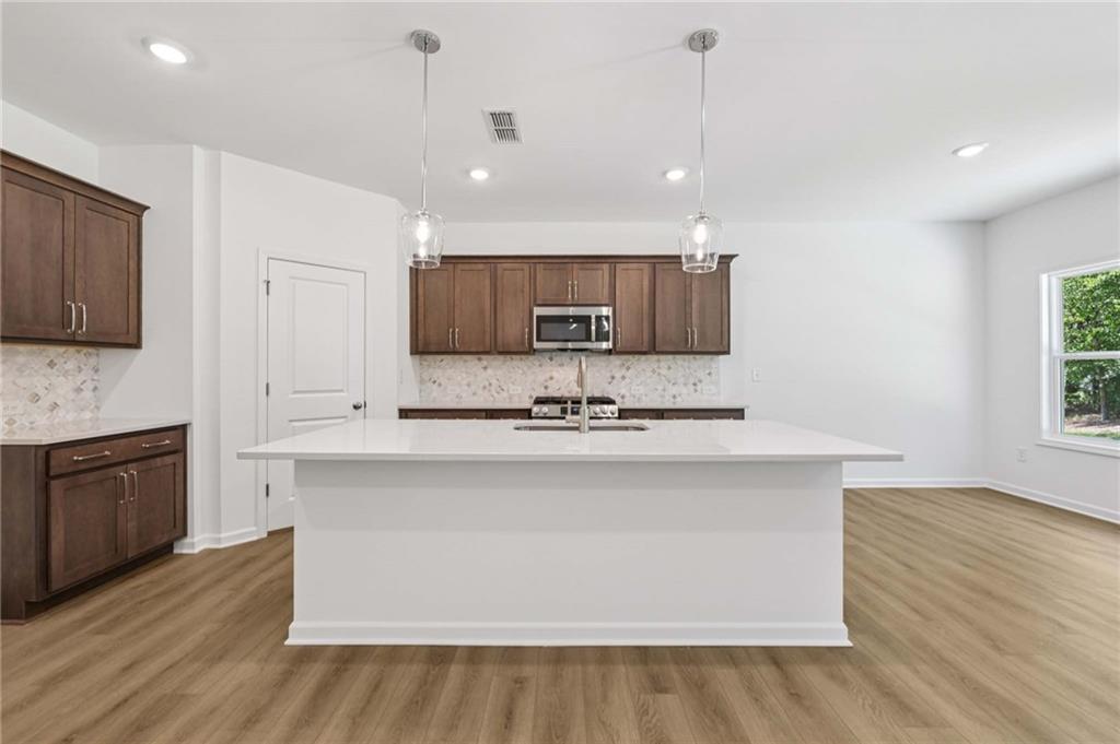 64 Silverleaf Trail Bethlehem, GA 30620 - Photo 12 of 44 a large kitchen with granite countertop a stove top oven a sink a counter space and cabinets