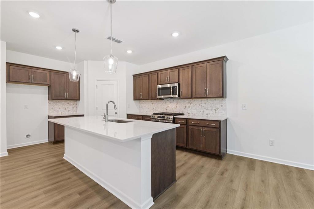 64 Silverleaf Trail Bethlehem, GA 30620 - Photo 13 of 44 a kitchen with stainless steel appliances granite countertop a sink stove and microwave