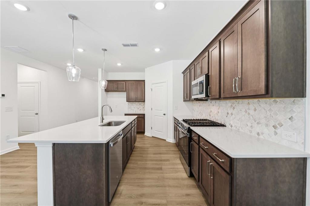 64 Silverleaf Trail Bethlehem, GA 30620 - Photo 14 of 44 a large kitchen with stainless steel appliances granite countertop a sink a stove and a wooden floors