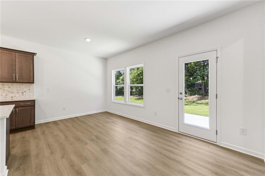 64 Silverleaf Trail Bethlehem, GA 30620 - Photo 17 of 44 a view of an empty room with a window and wooden floor