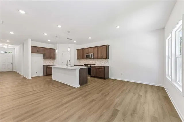 a large kitchen with stainless steel appliances granite countertop a stove a sink and a microwave