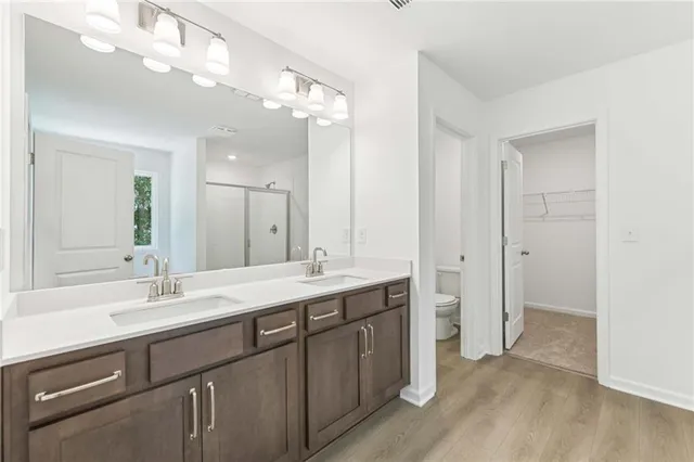 a bathroom with a double vanity sink and mirror with shower