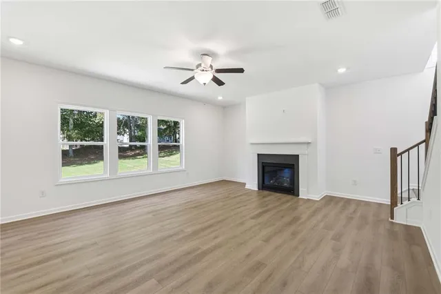 a view of an empty room with glass door and a fireplace