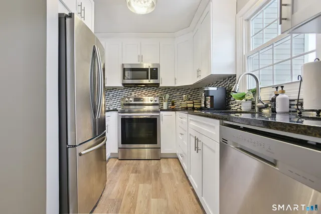 a kitchen with stainless steel appliances a stove sink and microwave