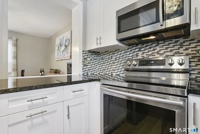 a kitchen with granite countertop cabinets stainless steel appliances and a sink