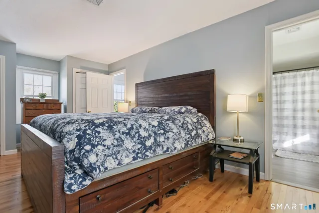 a bedroom with a bed and wooden floor
