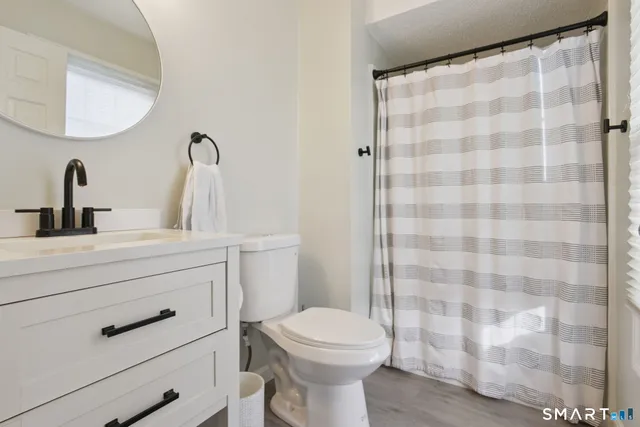 a bathroom with a sink a toilet and a mirror
