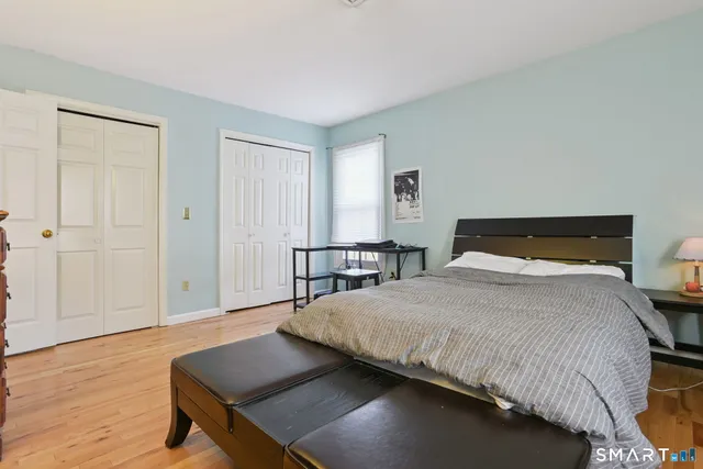 a bedroom with a bed and wooden floor