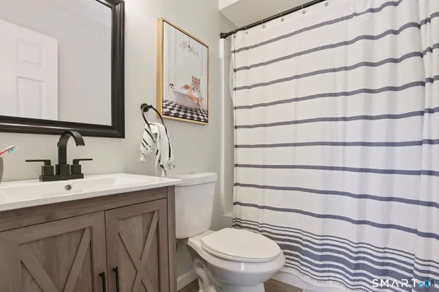 a bathroom with a toilet a sink and mirror