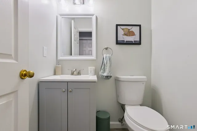 a bathroom with a toilet a sink and mirror