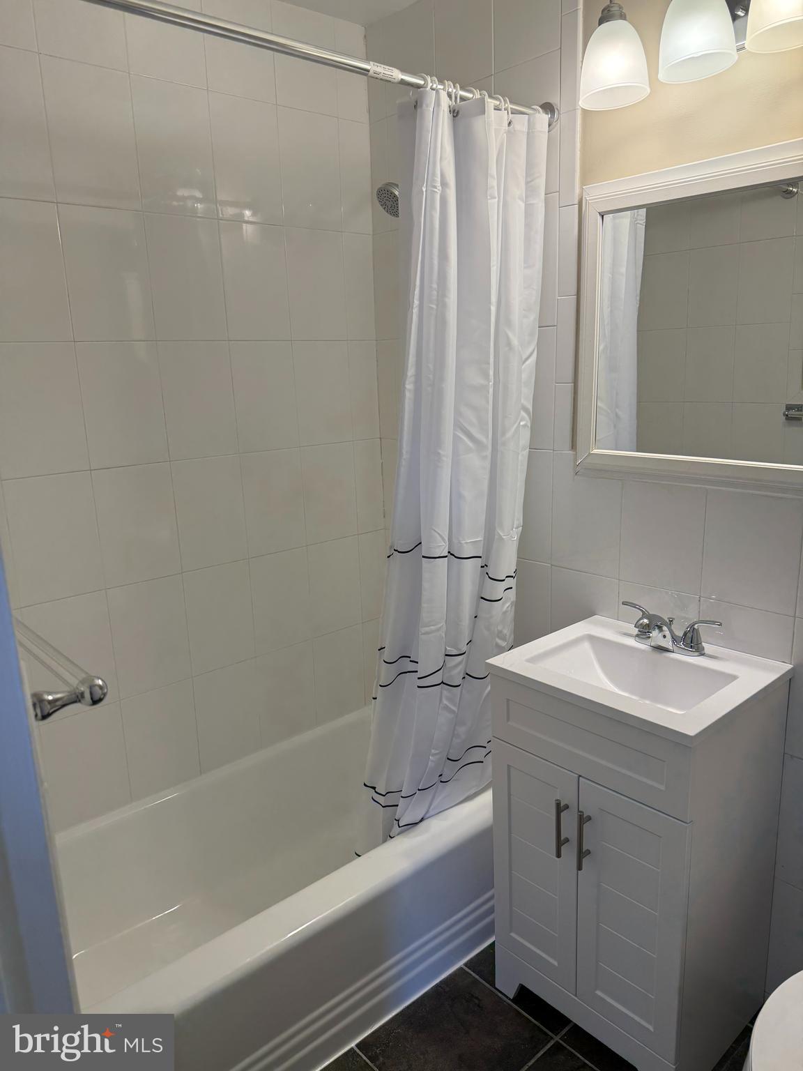 4840 MacArthur Boulevard Northwest, Unit 504 Washington, DC 20007 - Photo 8 of 10 a bathroom with a sink a mirror and a bathtub