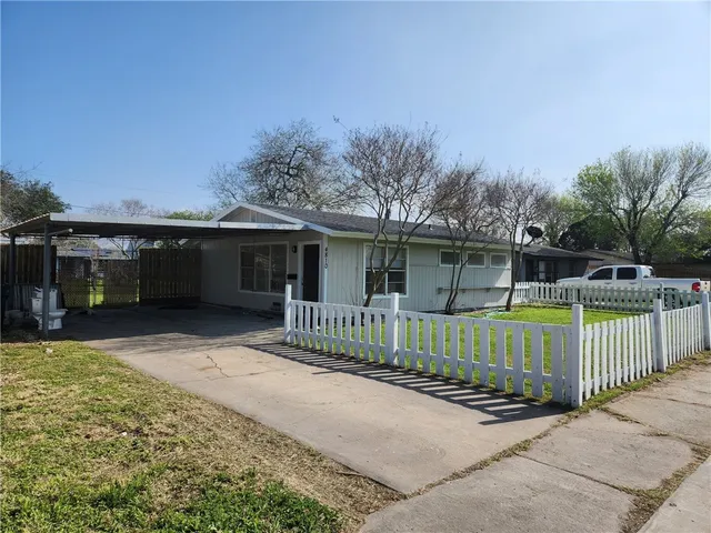 a front view of a house with a garden and yard