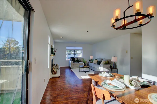 a living room with furniture a chandelier and a dining table