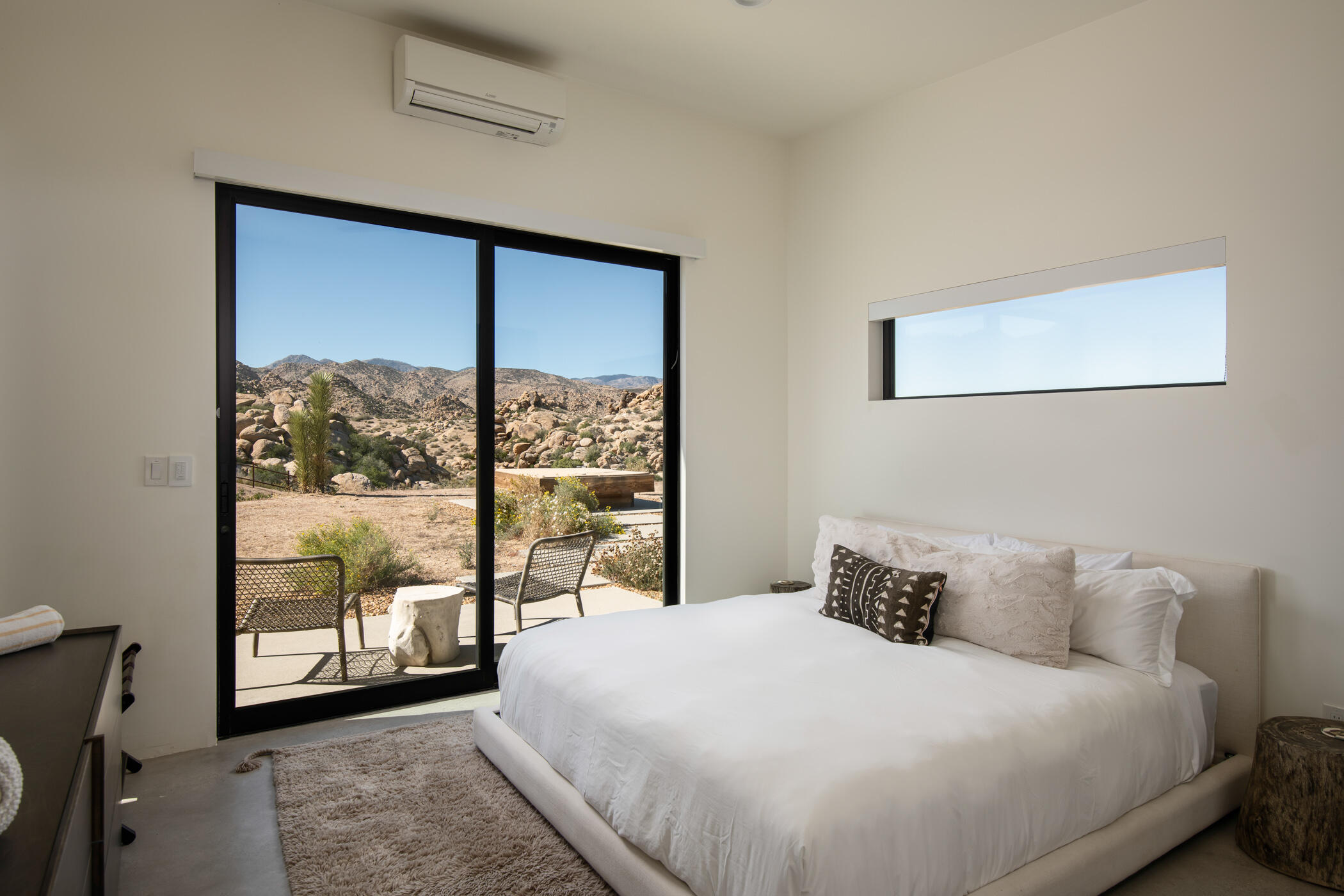 5494 Bronco Road Pioneertown, CA 92268 - Photo 23 of 38 a bedroom with a large window and a balcony