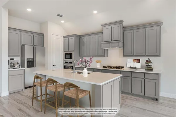 a kitchen with kitchen island granite countertop a sink stove and refrigerator