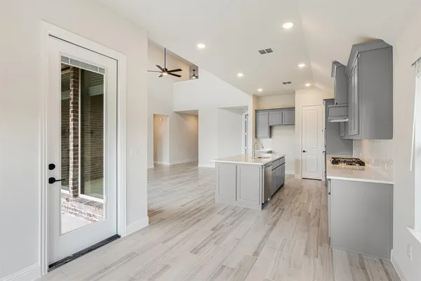 a large kitchen with a lot of counter space and a wooden floor