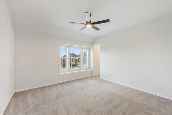 an empty room with window and ceiling fan