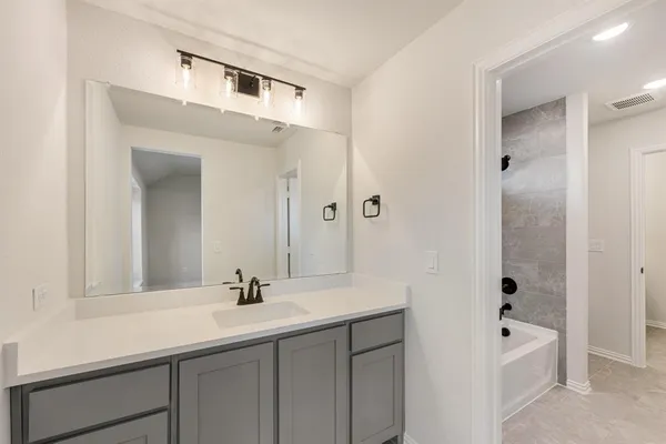 a bathroom with a bathtub a sink and mirror