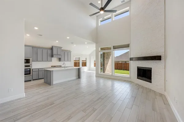 a large kitchen with cabinets wooden floor and a fireplace