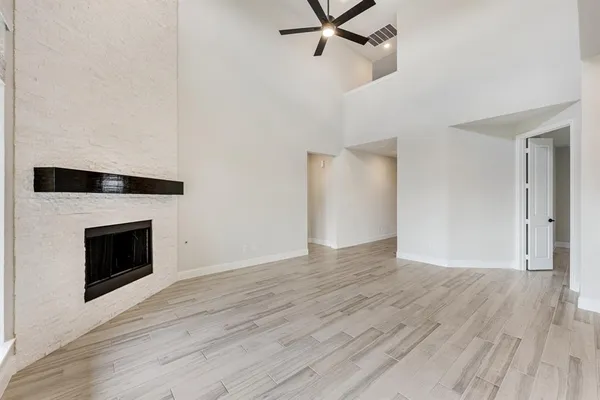 a view of empty room with wooden floor and fireplace