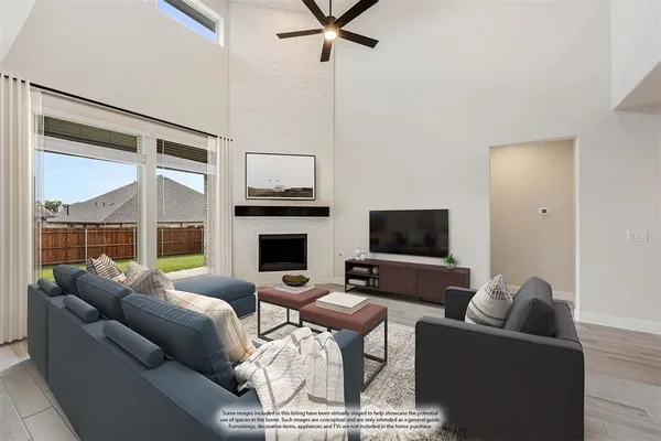 a living room with furniture a flat screen tv and a large window