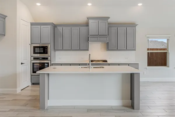 a kitchen with kitchen island a stove a sink and a refrigerator