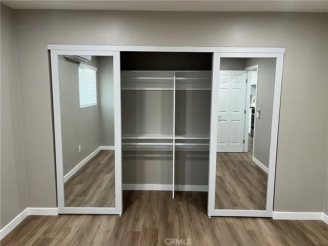 a kitchen with a refrigerator and wooden floor