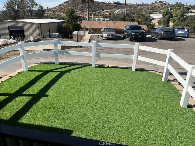 a view of a patio with table and chairs a fire pit and grass