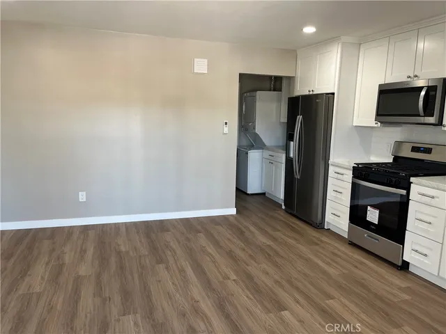 a kitchen with a refrigerator and a stove top oven
