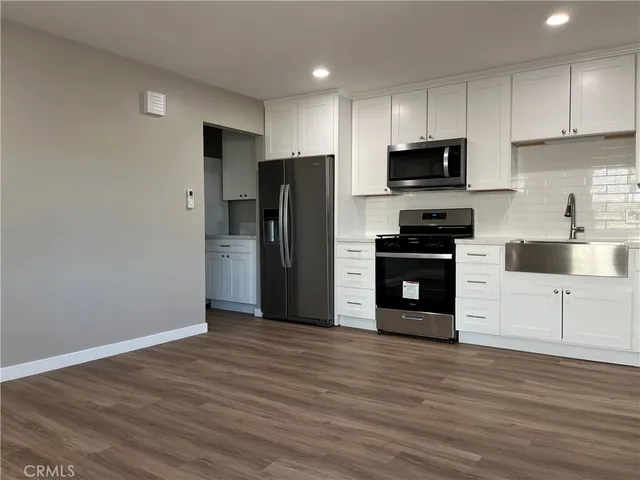 a kitchen with stainless steel appliances a refrigerator and a stove top oven
