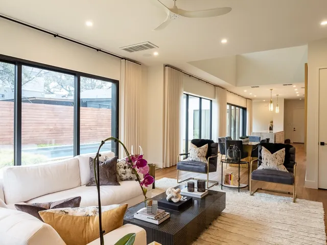 a living room with furniture and floor to ceiling windows