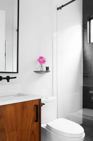 a bathroom with a toilet a sink and a mirror