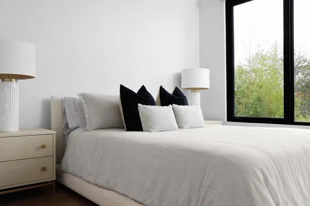 a large bed sitting in a bedroom next to a window