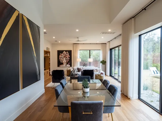 a living room with furniture large window and wooden floor