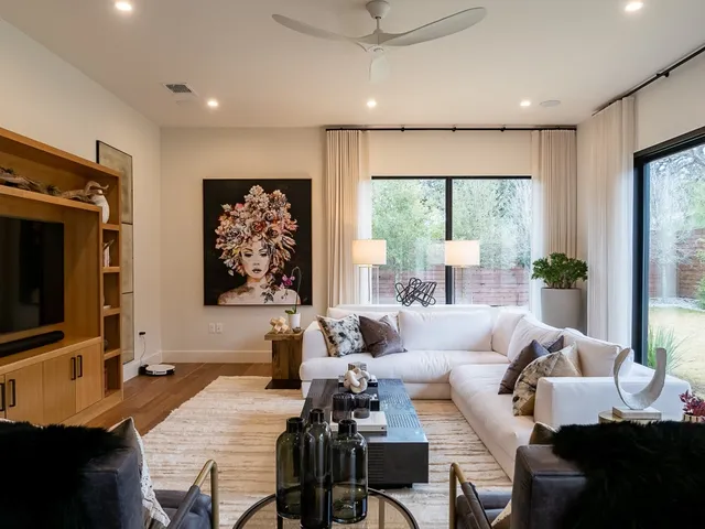 a living room with furniture a large window and a flat screen tv