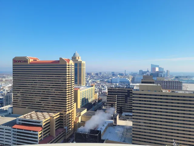 a bathroom with a granite countertop bathtub sink vanity mirror and toilet