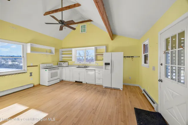 a kitchen with a refrigerator a sink and dishwasher with wooden floor