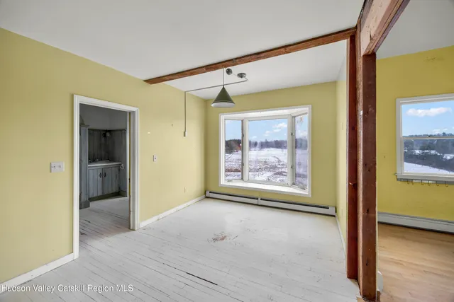 a view of an empty room with glass door and a window