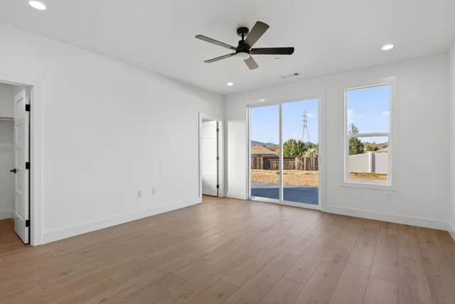 an empty room with wooden floor and windows