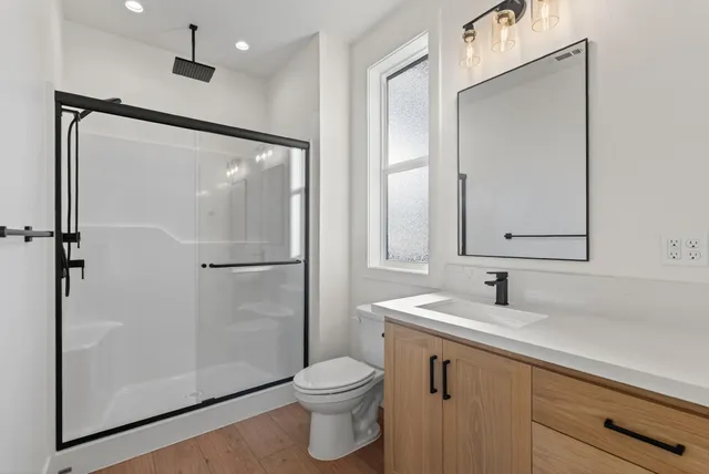 a bathroom with a shower a toilet and a sink